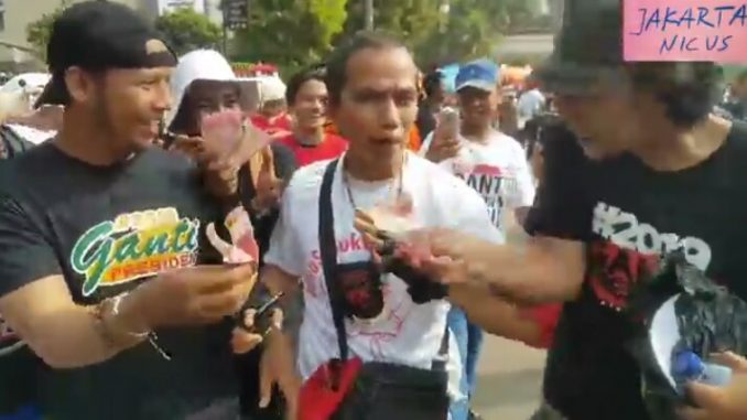 Seorang Ibu Berkauskan “#DiaSibukKerja” Diduga Diintimidasi Oleh Oknum Berkaus #GantiPresiden2019″