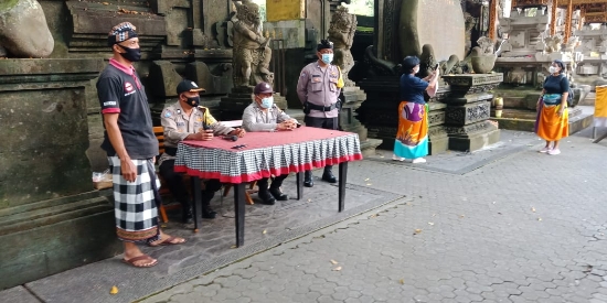 Sinergitas Polri Dengan Pecalang Ingatkan Warga Tetap Patuhi Prokes Pada Saat Persembahyangan Hari Raya Kuningan Di Pura Tirta Empul