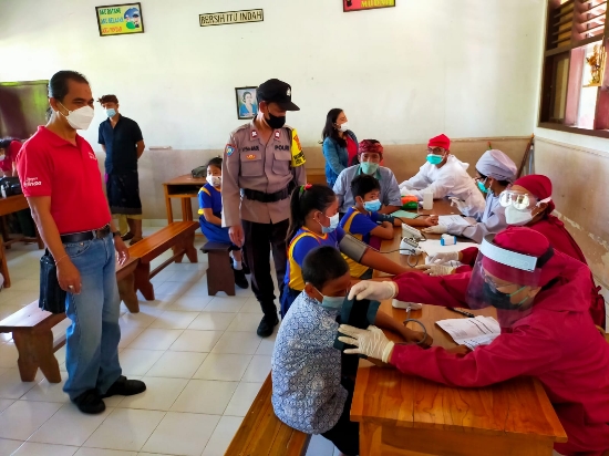 Personel Bhabinkamtibmas Polsek Gianyar Pengamanan Vaksinasi di SD