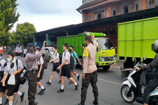 Pelayanan Prima Bhabinkamtibmas Suwat Seberangkan Anak Sekolah