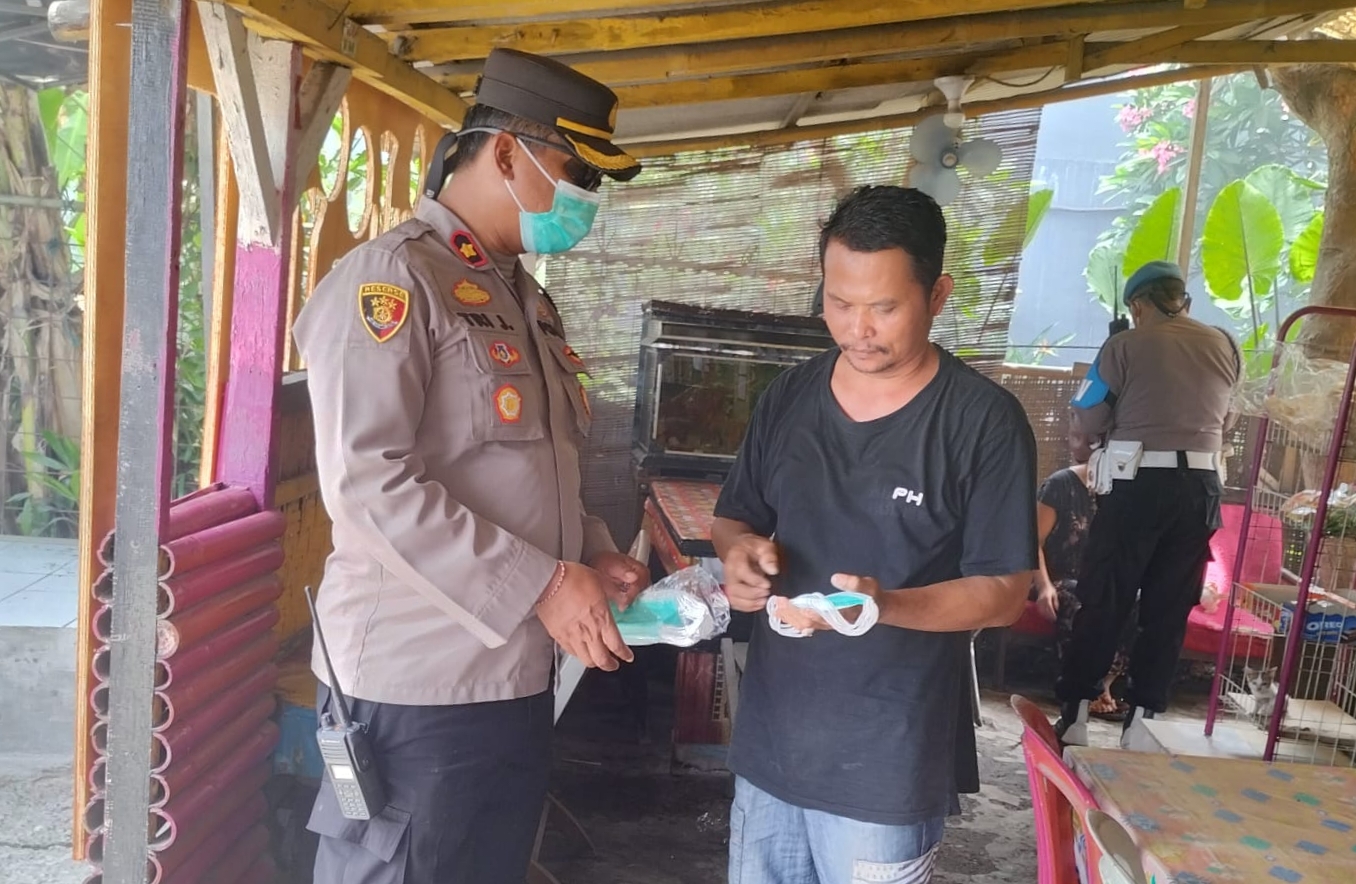 Kapolsek Benoa Bagikan Ribuan Masker kepada Warga Terdampak Kebakaran TPA Suwung