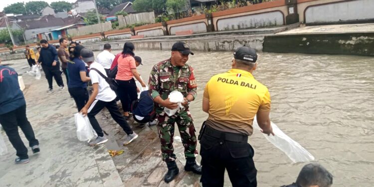 Babinsa bersama Pemerintah Desa Pemecutan Bersihkan Bantaran Tukad Badung dan Tabur Benih Ikan